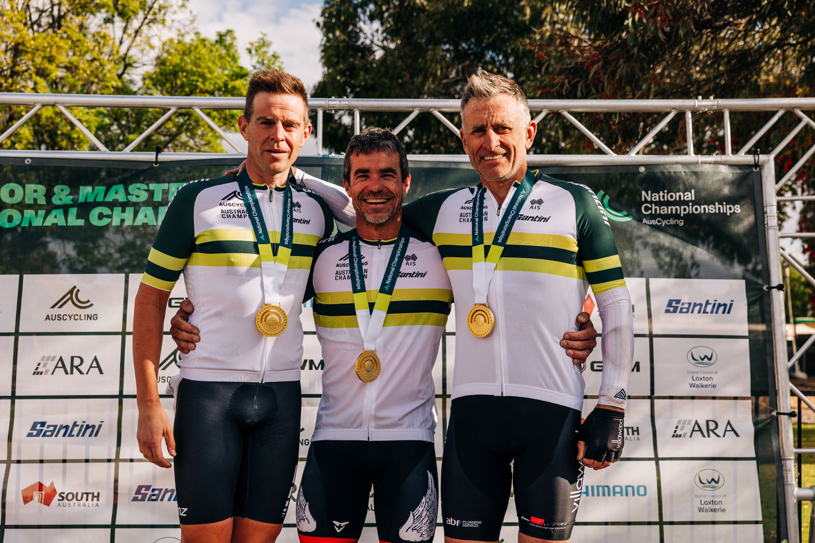 The winners of the men's masters 3, 4 and 5 Andrew Friebe, Chris Ling and Russell Van Hout on the podium after the road race at the 2024 AusCycling Masters and Junior Road National Championships in Loxton